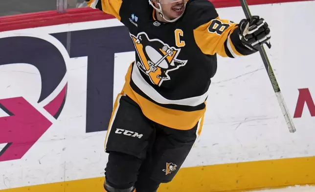 Pittsburgh Penguins' Sidney Crosby (87) celebrates after getting his 600th career goal in the NHL during the second period of an NHL hockey game against the Utah Hockey Club, Saturday, Nov. 23, 2024, in Pittsburgh. (AP Photo/Gene J. Puskar)