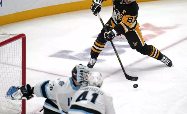 Pittsburgh Penguins' Sidney Crosby (87) gets off a shot for a goal past Utah Hockey Club goaltender Karel Vejmelka (70) for his 600th career goal in the NHL during the second period of an NHL hockey game Saturday, Nov. 23, 2024, in Pittsburgh. (AP Photo/Gene J. Puskar)