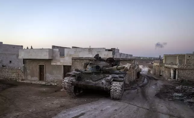 A destroyed Syrian army tank sits in the village of Anjara, western outskirts of Aleppo, Syria, Thursday Nov. 28, 2024. (AP Photo/Omar Albam)