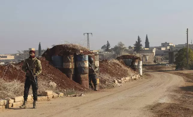 Syrian opposition fighters stand guard in Kafr Halab, Aleppo countryside, Syria, Friday, Nov. 29, 2024. (AP Photo/Ghaith Alsayed)
