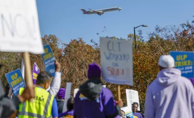 An airplane arrives at Charlotte Douglas International Airport as airport workers strike in front of the Charlotte Douglas International Airport in Charlotte, N.C., Monday, Nov. 25, 2024. (AP Photo/Nell Redmond)