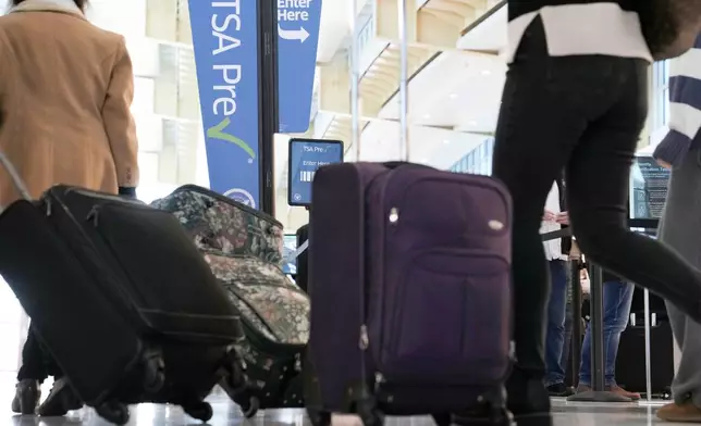 FILE - As the Thanksgiving holiday approaches, travelers walk through Reagan Washington National Airport in Arlington, Va., on Nov. 22, 2023. (AP Photo/Susan Walsh, File)