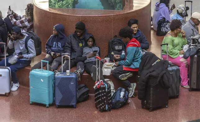 Travelers wait at Hartsfield-Jackson International Airport, Friday, Nov. 22, 2024, in Atlanta, as the Thanksgiving travel season kicks off. (John Spink/Atlanta Journal-Constitution via AP)