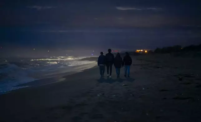 FILE - Survivors and relatives of victims walk, Feb. 26, 2024, at the site where a migrant boat capsized a year earlier in Steccato di Cutro, on the Italian southern tip. AP Photo/Valeria Ferraro, File)