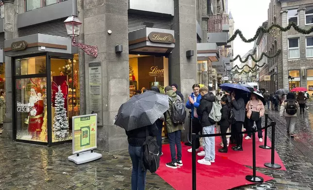 People queue outside of a Lindt chocolate shop to buy limited bars 'Dubai Chocolate', in Aachen, Germany, Thursday, Nov. 14, 2024. (AP Photo/Daniel Niemann)