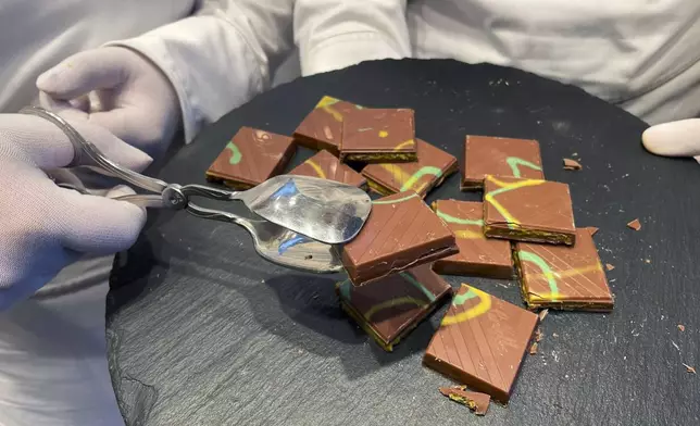 Service employees offer "Dubai Chocolate" in a Lindt shop to customers during the sell of limited bars of the Chocolate, in Aachen, Germany, Thursday, Nov. 14, 2024. (AP Photo/Daniel Niemann)