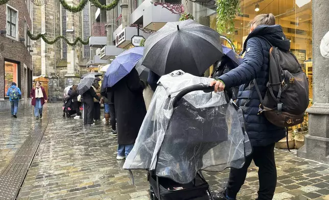 People queue outside a Lindt chocolate shop to buy limited bars of 'Dubai Chocolate', in Aachen, Germany, Thursday, Nov. 14, 2024. (AP Photo/Daniel Niemann)