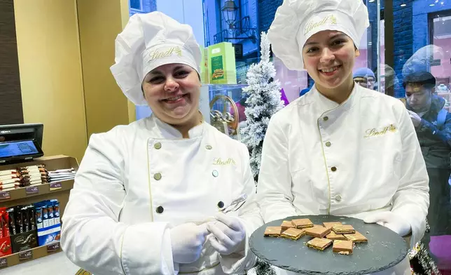 Service employees offer "Dubai Chocolate" in a Lindt shop to customers, during the sell of limited bars of the Chocolate in Aachen, Germany, Thursday, Nov. 14, 2024. (AP Photo/Daniel Niemann)