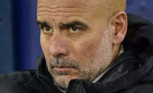 Manchester City's head coach Pep Guardiola takes his seat on the bench before the Champions League opening phase soccer match between Manchester City and Feyenoord at the Etihad Stadium in Manchester, England, Tuesday, Nov. 26, 2024. (AP Photo/Dave Thompson)