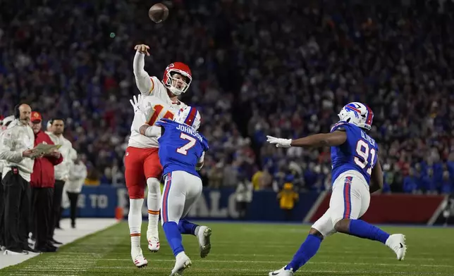 Kansas City Chiefs quarterback Patrick Mahomes (15) throws over Buffalo Bills cornerback Taron Johnson (7) and defensive tackle Ed Oliver (91) during the first half of an NFL football game Sunday, Nov. 17, 2024, in Orchard Park, N.Y. (AP Photo/Julia Demaree Nikhinson)