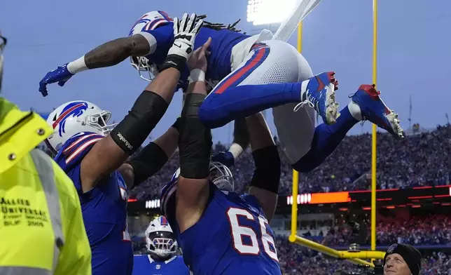 Buffalo Bills running back James Cook is lifted by teammate Connor McGovern (66) after scoring during the first half of an NFL football game against the Kansas City Chiefs Sunday, Nov. 17, 2024, in Orchard Park, N.Y. (AP Photo/Julia Demaree Nikhinson)