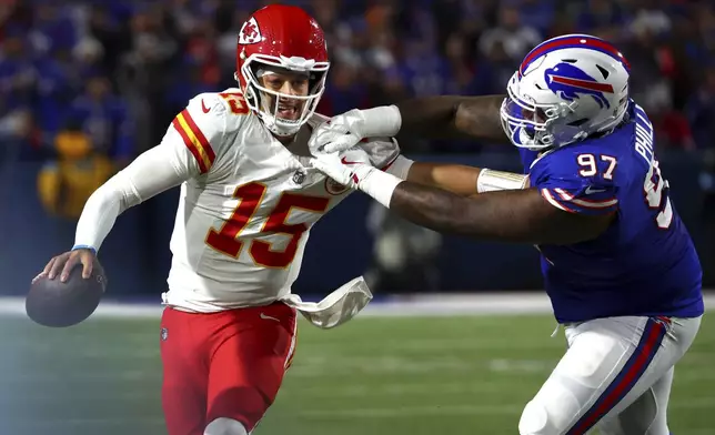 Kansas City Chiefs quarterback Patrick Mahomes (15) scrambles away from Buffalo Bills defensive tackle Jordan Phillips (97) during the second half of an NFL football game Sunday, Nov. 17, 2024, in Orchard Park, N.Y. (AP Photo/Jeffrey T. Barnes)