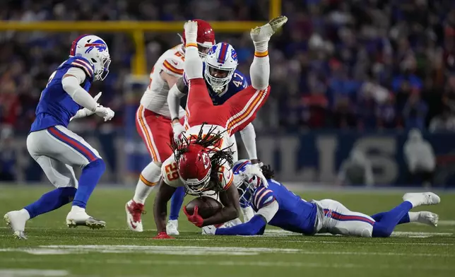 Kansas City Chiefs running back Kareem Hunt (29) leaps over Buffalo Bills safety Damar Hamlin, right, during the first half of an NFL football game Sunday, Nov. 17, 2024, in Orchard Park, N.Y. (AP Photo/Julia Demaree Nikhinson)