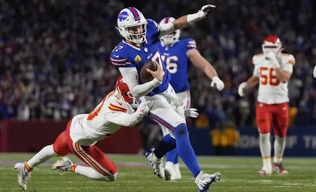 Buffalo Bills quarterback Josh Allen (17) slips past Kansas City Chiefs cornerback Nazeeh Johnson to score on a 26-yard run during the second half of an NFL football game Sunday, Nov. 17, 2024, in Orchard Park, N.Y. (AP Photo/Julia Demaree Nikhinson)