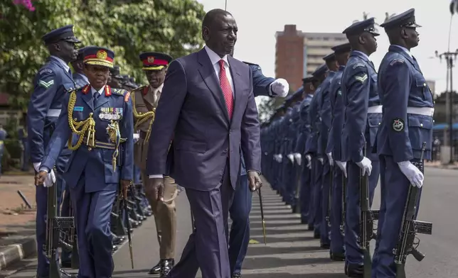 Kenyan President William Ruto, center, reviews the honour guard after arriving to give the State of The Nation address at Parliament buildings in Nairobi, Kenya, Thursday, Nov. 21, 2024. (AP Photo/Brian Inganga)