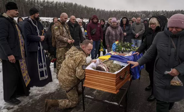 Ukrainian serviceman Roman bids farewell to his comrade of the 47th brigade Serhii Solovyov who was killed during fighting with Russian Forces in Kursk oblast on November 12, during the funeral ceremony in Irpin, Kyiv region, Ukraine, Nov. 21, 2024. (AP Photo/Evgeniy Maloletka)