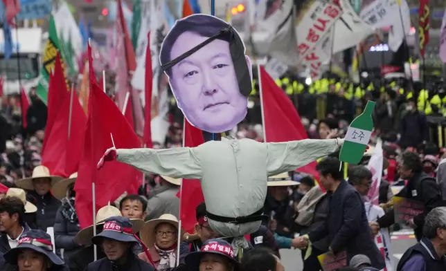 Members of the national federation of farmers, known as "Junnong," and the Korean Confederation of Trade Unions, march with an effigy of South Korean President Yoon Suk Yeol during a rally to demand the suspension of rice imports and Yoon's resignation in Seoul, South Korea, Wednesday, Nov. 20, 2024. (AP Photo/Ahn Young-joon)