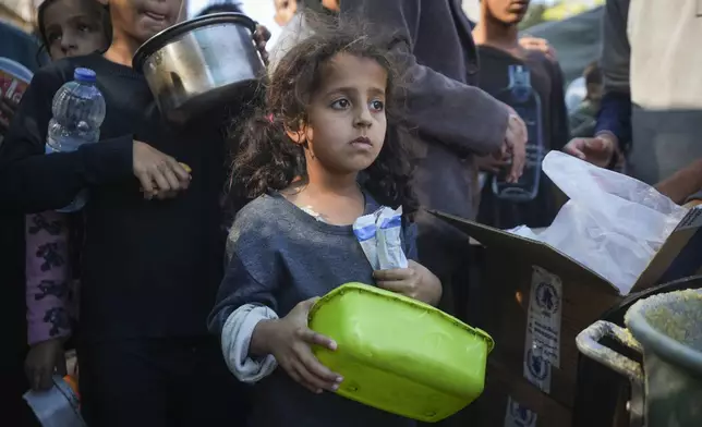 A Palestinian little girl queues for food in Deir al-Balah, Gaza Strip, Monday, Nov. 18, 2024. (AP Photo/Abdel Kareem Hana)