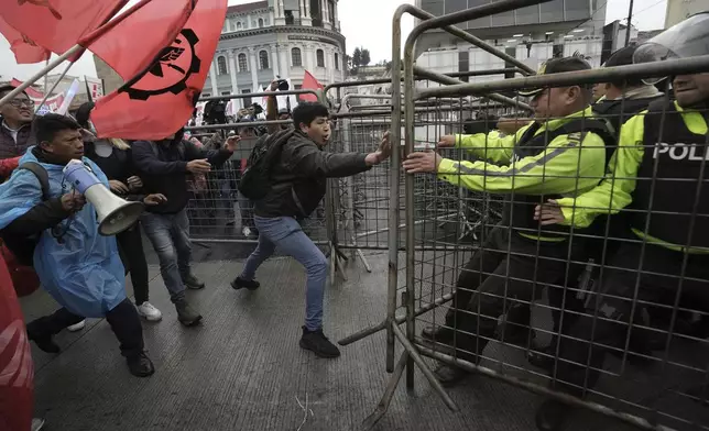 Anti-government protesters challenge police during a demonstration against electricity rationing in Quito, Ecuador, Thursday, Nov. 21, 2024. (AP Photo/Dolores Ochoa)