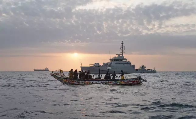 Senegalese sailors on their zodiac, background, approach a fishermen's pirogue to check during a mission to search for illegal migrant boats near the coast of Dakar, Senegal, Saturday, Nov.16, 2024. (AP Photo/Sylvain Cherkaoui)