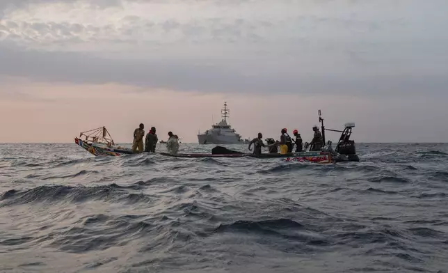 Senegalese sailors in their zodiac, background, approach a fishermen's pirogue to check during a mission to search for illegal migrant boats near the coast of Dakar, Senegal, Saturday, Nov.16, 2024. (AP Photo/Sylvain Cherkaoui)