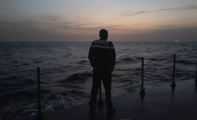 A sailor observes the sunrise from the deck of the offshore patrol vessel Niani during a mission to search for illegal migrant boats near the coast of Dakar, Senegal, Saturday, Nov.16, 2024. (AP Photo/Sylvain Cherkaoui)