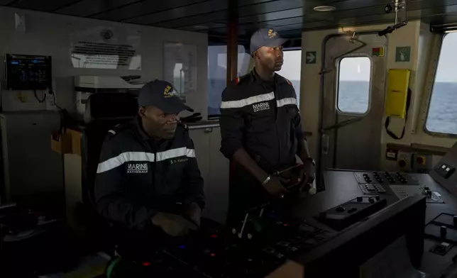 Senegalese sailors survey the sea at the offshore patrol vessel Niani during a mission to search for illegal migrant boats near the coast of Dakar, Senegal, Saturday, Nov.16, 2024. (AP Photo/Sylvain Cherkaoui)