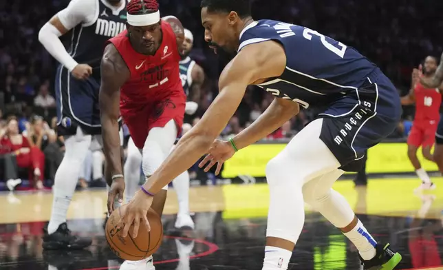 Miami Heat forward Jimmy Butler (22) battles with Dallas Mavericks forward P.J. Washington (25) for a loose ball during the second half of an NBA basketball game, Sunday, Nov. 24, 2024, in Miami. (AP Photo/Jim Rassol)