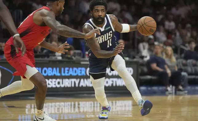 Dallas Mavericks guard Kyrie Irving (11) brings the ball upcourt as Miami Heat forward Haywood Highsmith, left, defends during the first half of an NBA basketball game, Sunday, Nov. 24, 2024, in Miami. (AP Photo/Jim Rassol)