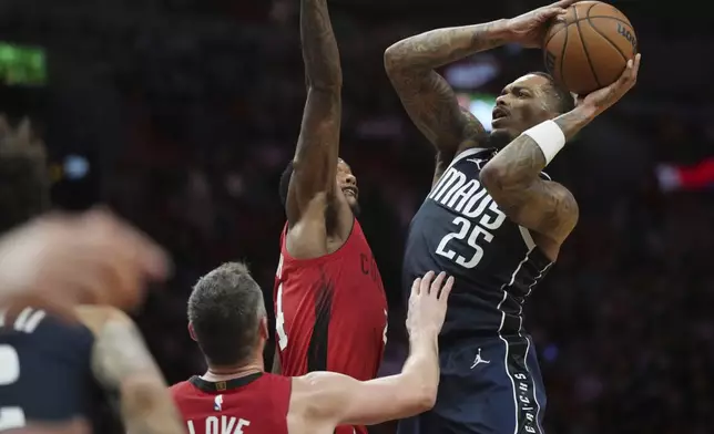 Dallas Mavericks forward P.J. Washington (25) goes up for a shot as Miami Heat forward Haywood Highsmith (24) defends during the first half of an NBA basketball game, Sunday, Nov. 24, 2024, in Miami. (AP Photo/Jim Rassol)