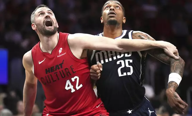 Miami Heat forward Kevin Love (42) boxes out Dallas Mavericks forward P.J. Washington (25) during the first half of an NBA basketball game, Sunday, Nov. 24, 2024, in Miami. (AP Photo/Jim Rassol)