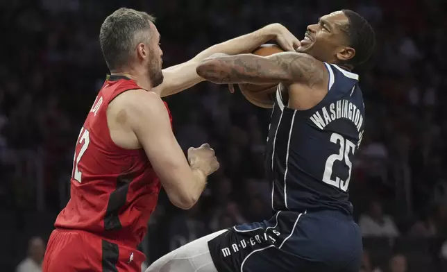 Miami Heat forward Kevin Love, left, strips the ball away from Dallas Mavericks forward P.J. Washington (25) during the first half of an NBA basketball game, Sunday, Nov. 24, 2024, in Miami. (AP Photo/Jim Rassol)