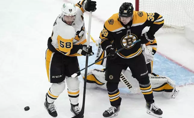 Pittsburgh Penguins' Kris Letang (58) defends against Boston Bruins' Morgan Geekie (39) during the first period of an NHL hockey game, Friday, Nov. 29, 2024, in Boston. (AP Photo/Michael Dwyer)