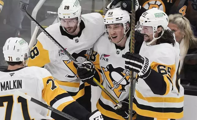 Pittsburgh Penguins' Philip Tomasino (53) celebrates his goal with Evgeni Malkin (71), Erik Karlsson (65) and Marcus Pettersson (28) during the third period of an NHL hockey game against the Boston Bruins, Friday, Nov. 29, 2024, in Boston. (AP Photo/Michael Dwyer)