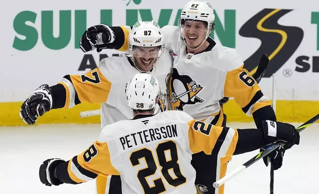 Pittsburgh Penguins' Rickard Rakell (67) celebrates after his goal with Sidney Crosby (87) and Marcus Pettersson (28) during the second period of an NHL hockey game against the Boston Bruins, Friday, Nov. 29, 2024, in Boston. (AP Photo/Michael Dwyer)