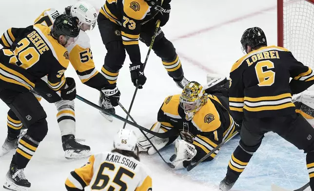 Boston Bruins' Jeremy Swayman (1) blocks a shot by Pittsburgh Penguins' Philip Tomasino (53) during the second period of an NHL hockey game, Friday, Nov. 29, 2024, in Boston. (AP Photo/Michael Dwyer)