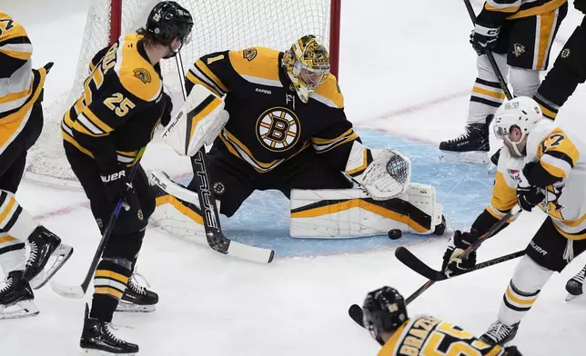 Boston Bruins' Jeremy Swayman (1) blocks a shot by Pittsburgh Penguins' Bryan Rust (17) during the first period of an NHL hockey game, Friday, Nov. 29, 2024, in Boston. (AP Photo/Michael Dwyer)