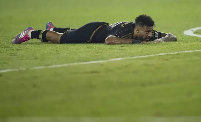 Los Angeles FC forward Denis Bouanga (99) reacts after missing a shot during overtime in an MLS Western Conference semifinal soccer match against the Seattle Sounders in Los Angeles, Saturday, Nov. 23, 2024. (AP Photo/Kyusung Gong)