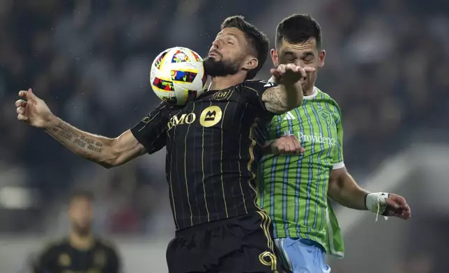 Los Angeles FC forward Olivier Giroud, left, controls the ball in front of Seattle Sounders defender Jackson Ragen during the second half of an MLS Western Conference semifinal soccer match in Los Angeles, Saturday, Nov. 23, 2024. (AP Photo/Kyusung Gong)