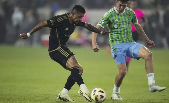 Los Angeles FC forward Cristian Olivera, left, shoots as Seattle Sounders midfielder Reed Baker-Whiting defends during the second half of an MLS Western Conference semifinal soccer match in Los Angeles, Saturday, Nov. 23, 2024. (AP Photo/Kyusung Gong)