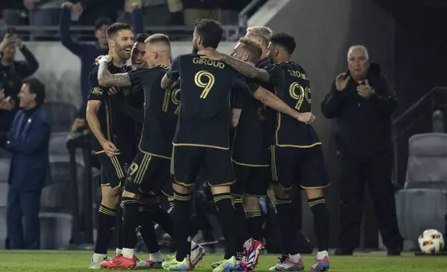 Los Angeles FC players celebrate a goal by midfielder Ryan Hollingshead (24) during the second half of an MLS Western Conference semifinal soccer match against the Seattle Sounders in Los Angeles, Saturday, Nov. 23, 2024. (AP Photo/Kyusung Gong)