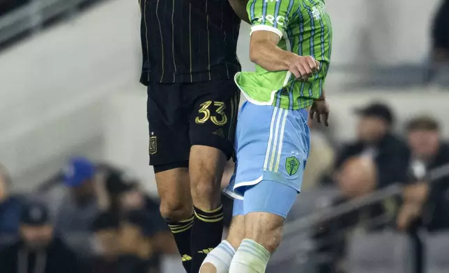 Los Angeles FC defender Aaron Long, left, and Seattle Sounders forward Pedro De La Vega battle for a header during the second half of an MLS Western Conference semifinal soccer match in Los Angeles, Saturday, Nov. 23, 2024. (AP Photo/Kyusung Gong)