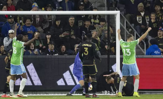 Los Angeles FC defender Maxime Chanot, bottom right, looks away as an own goal goes into the net during the second half of an MLS Western Conference semifinal soccer match against the Seattle Sounders in Los Angeles, Saturday, Nov. 23, 2024. (AP Photo/Kyusung Gong)