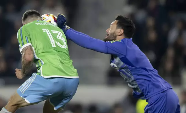 Los Angeles FC goalkeeper Hugo Lloris, right, blocks a header by Seattle Sounders forward Jordan Morris during the first half of an MLS Western Conference semifinal soccer match in Los Angeles, Saturday, Nov. 23, 2024. (AP Photo/Kyusung Gong)