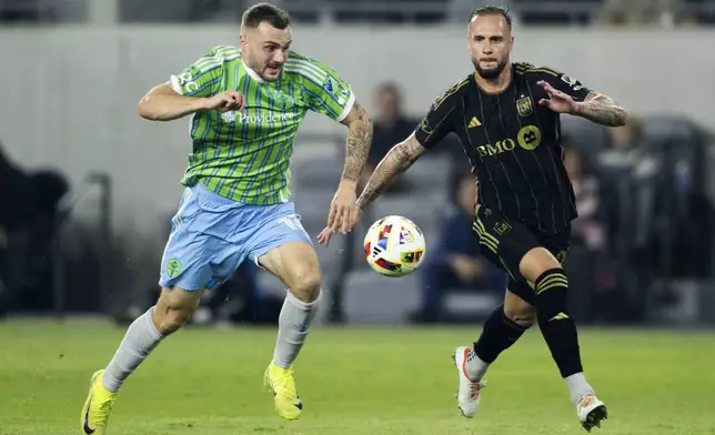 Seattle Sounders forward Jordan Morris, left, dribbles the ball as Los Angeles FC defender Maxime Chanot chases during the first half of an MLS Western Conference semifinal soccer match in Los Angeles, Saturday, Nov. 23, 2024. (AP Photo/Kyusung Gong)