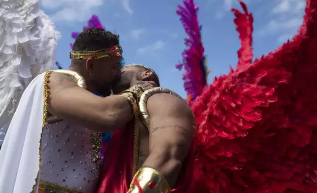 A couple dressed as angels kiss during the 29th LGBTI+ Rio Pride Parade along Copacabana beach in Rio de Janeiro, Sunday, Nov. 24, 2024. (AP Photo/Bruna Prado)