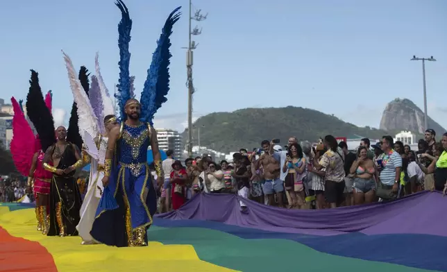 People dressed as angels perform during the 29th LGBTI+ Rio Pride Parade along Copacabana beach in Rio de Janeiro, Sunday, Nov. 24, 2024. (AP Photo/Bruna Prado)