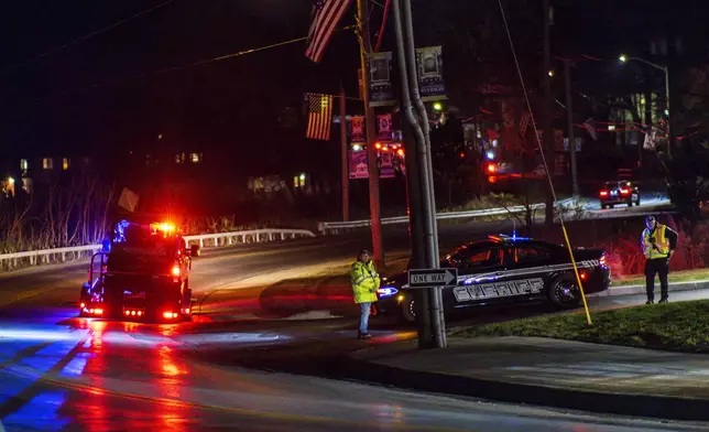 Police officers stand guard on a local road as wildfires burn along the New York and New Jersey border in Greenwood Lake, New York, Wednesday, Nov. 13, 2024. (AP Photo/Eduardo Munoz Alvarez)