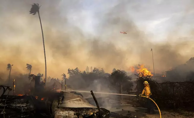 FILE - Firefighters work against the Mountain Fire, Nov. 6, 2024, near Camarillo, Calif. (AP Photo/Ethan Swope,FIle)