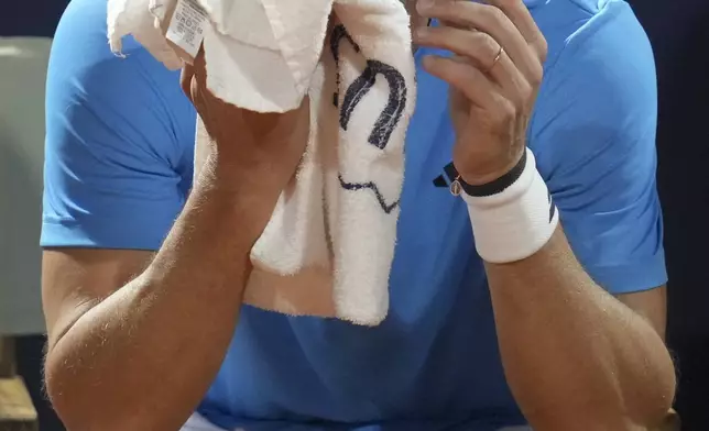 Uruguay's Diego Forlan holds a towel up to his face during a men's doubles tennis match against Boris Arias and Federico Zeballos at the 2024 Uruguay Open in Montevideo, Uruguay, Wednesday, Nov. 13, 2024. (AP Photo/Matilde Campodonico)